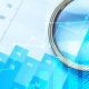 Mano con lente d'ingrandimento su grafici statistici e dati finanziari in tonalità blu